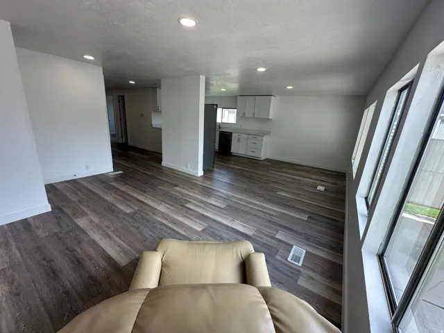 Open concept living space featuring wood-finish flooring, recessed lighting, and multiple windows