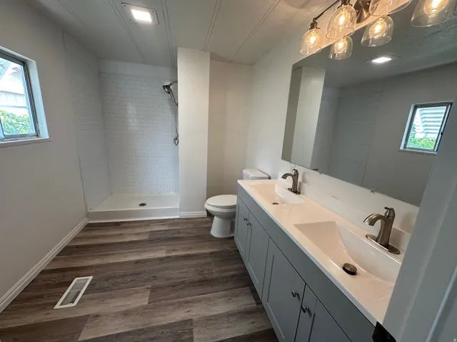 Bathroom featuring a dual vanity with integrated sinks, brushed nickel fixtures, and a six-light vanity sconce