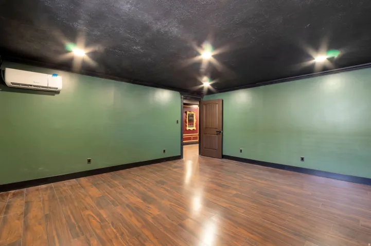 Wood-finish flooring with dark baseboards and crown molding