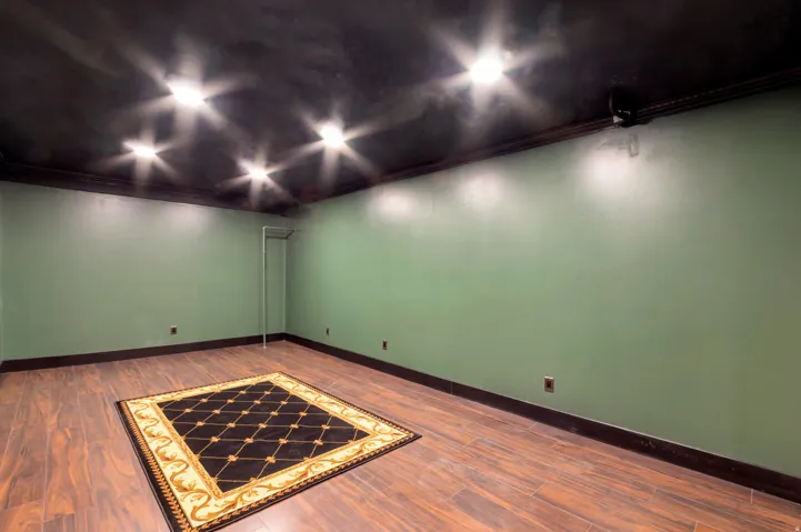 Spacious room featuring wood-finish flooring, dark crown molding, and recessed lighting