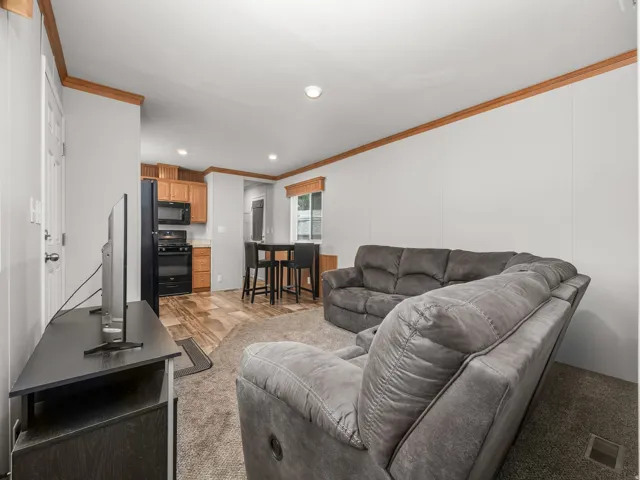 Open-concept living space with light-toned walls and wood-finish trim