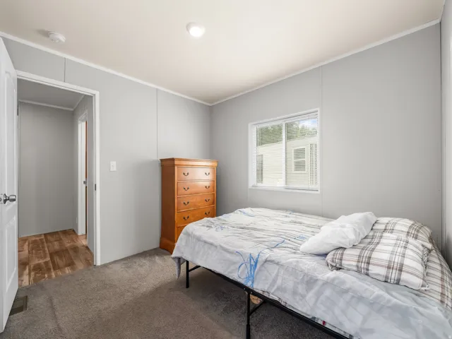 Bedroom featuring neutral grey walls and a single window with horizontal blinds