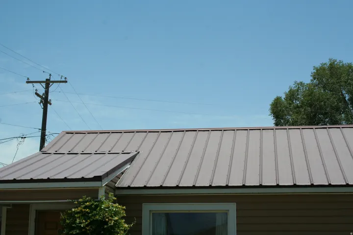 Brown standing-seam metal roofing with a visible eave and gutter system
