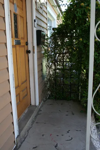 Wood-paneled entry door with frosted glass insert, flanked by light-toned siding