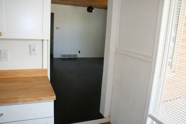 Kitchen area featuring light wood-finish countertops and white cabinetry