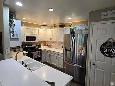 Kitchen featuring white cabinetry, white countertops, stainless steel appliances, a subway tile backsplash, and recessed lighting
