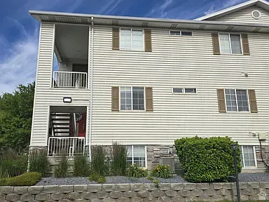 Multi-level exterior featuring light-colored siding and stone accents