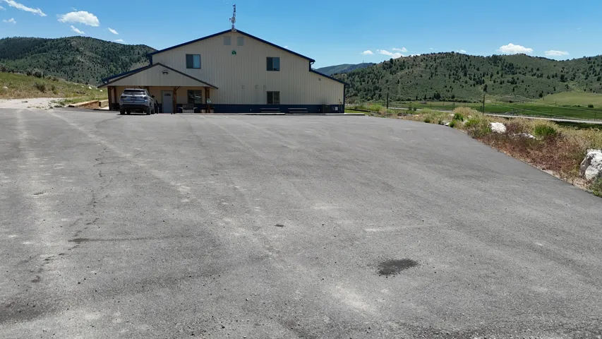 Expansive paved parking area fronting a two-story commercial-style building with a covered entry