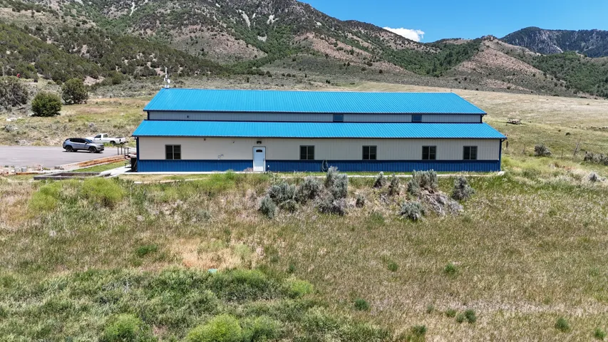 Long commercial building featuring a vibrant blue metal roof and two-tone blue and white siding