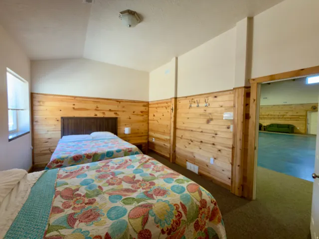 Interior room featuring natural wood paneling, sloped ceiling, and a rectangular window