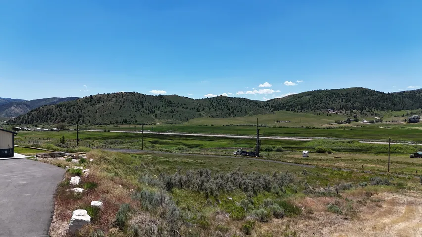 Expansive natural landscape with distant rolling hills and verdant fields