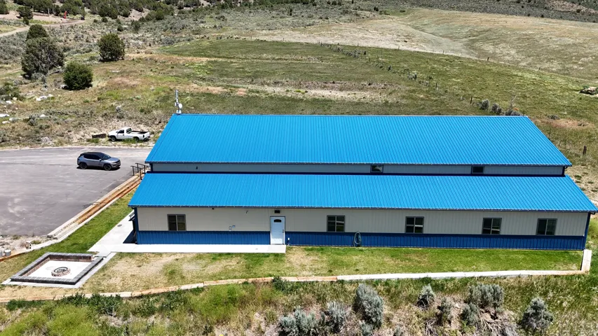 Expansive metal structure featuring a vibrant blue corrugated metal roof and white siding with a blue accent band