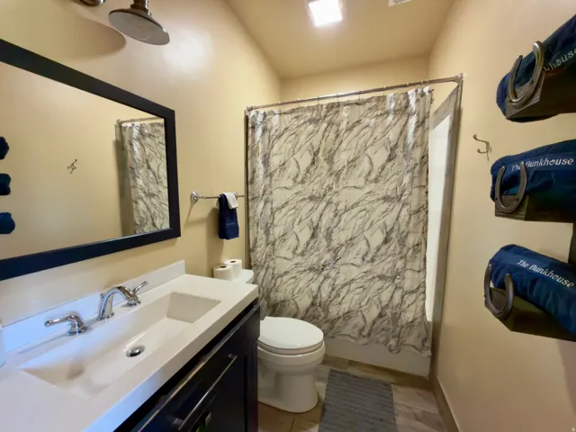 Bathroom featuring a vanity with integrated sink, chrome faucet, and dark wood cabinetry