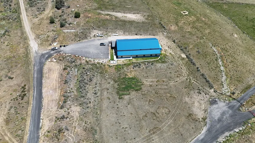 Aerial perspective showcasing a large industrial-style building with a vibrant blue roof