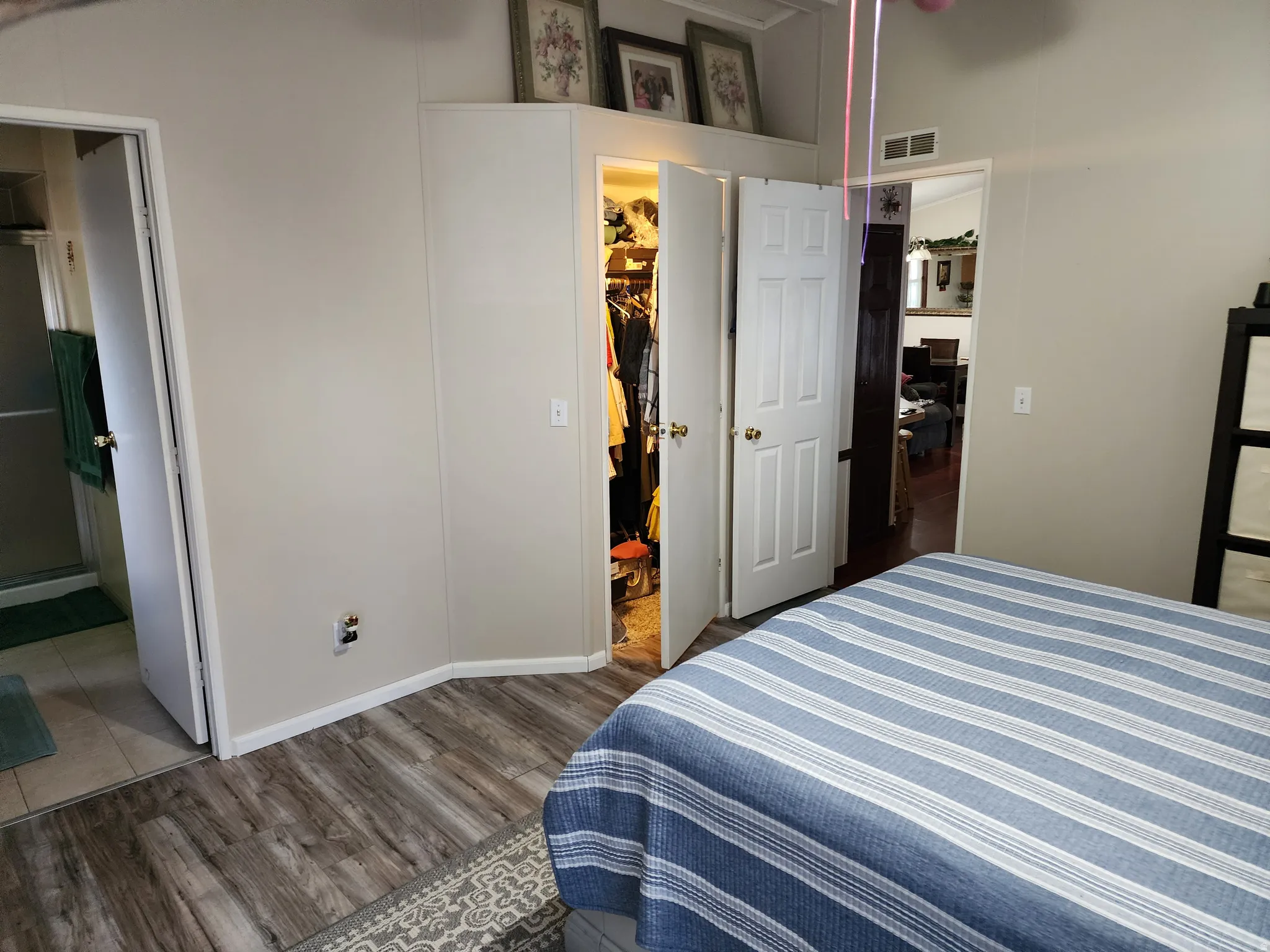 Spacious room featuring wood-finish flooring and a walk-in closet with double doors