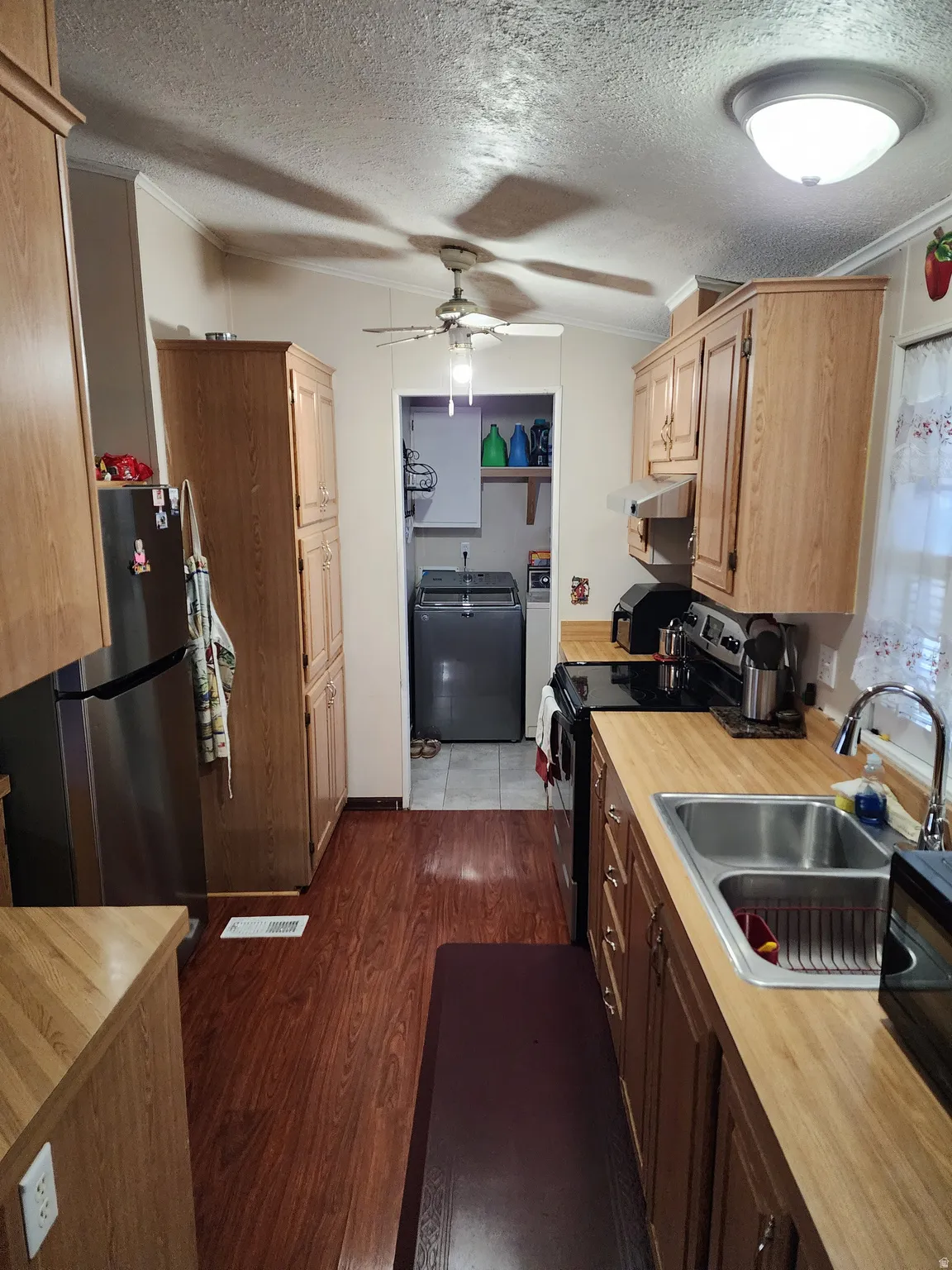 Kitchen featuring wood-finish flooring, oak cabinetry, and light-toned countertops