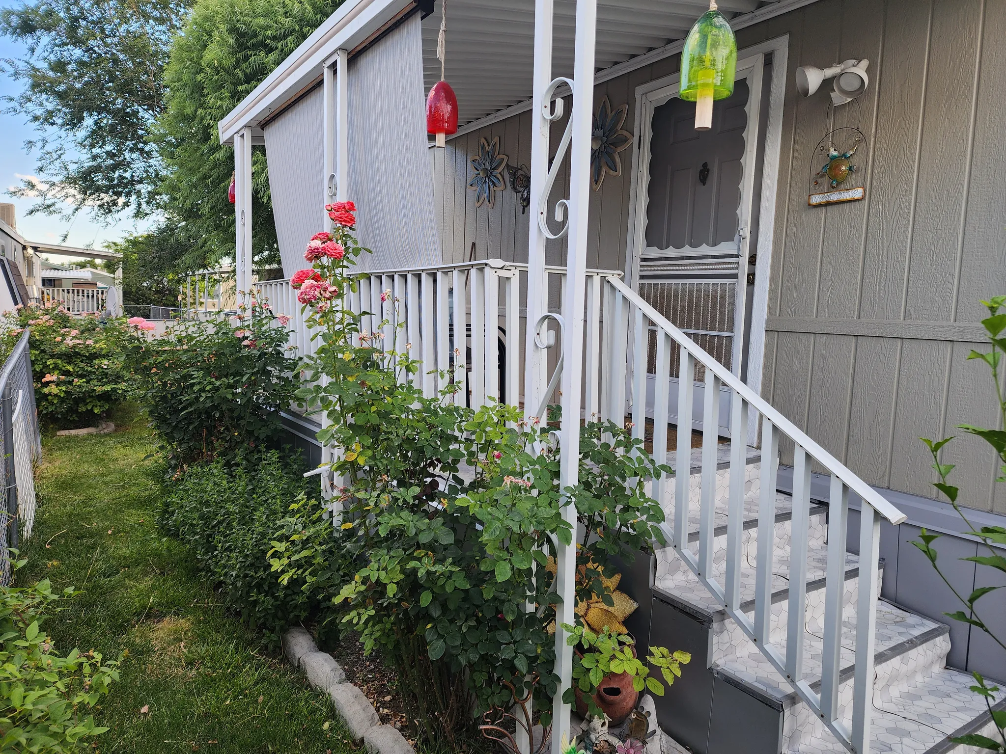Exterior siding with a covered porch featuring white railing and tiled steps