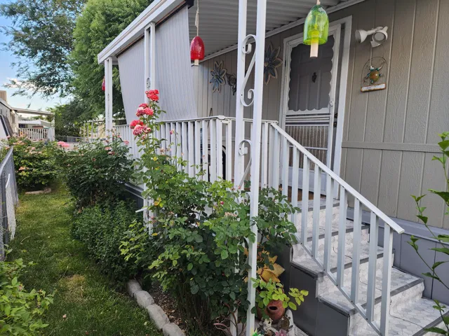 Exterior siding with a covered porch featuring white railing and tiled steps