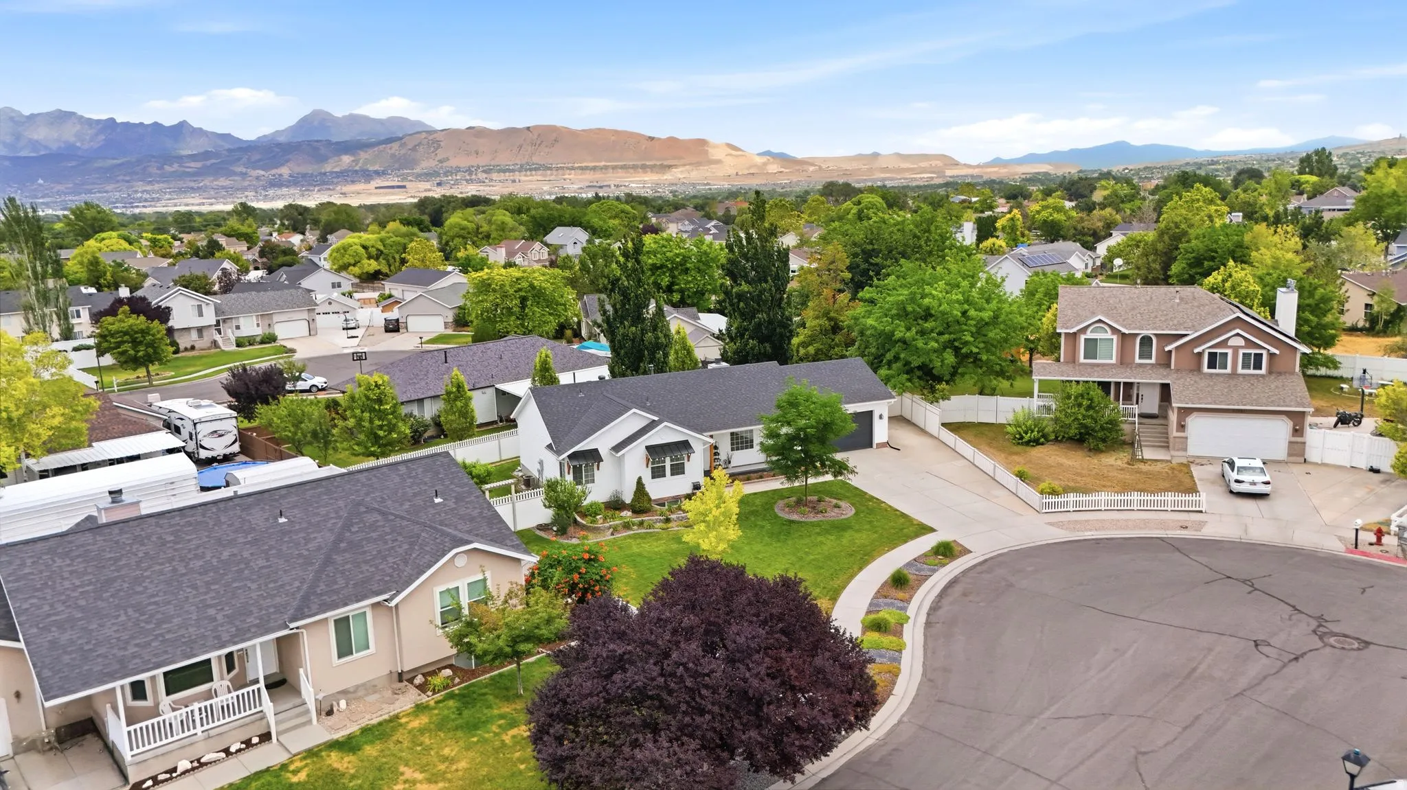 Residential street featuring mature landscaping and mountain scenery