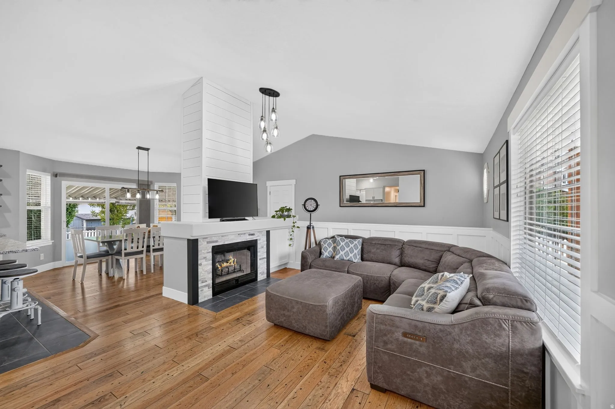 Spacious interior featuring wood-finish flooring and a central fireplace with a shiplap accent wall