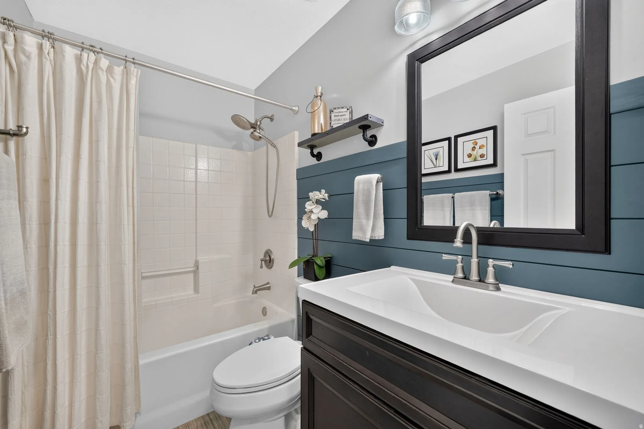 Modern bathroom featuring a wood-finish vanity with an integrated white sink and brushed nickel faucet