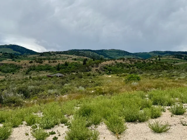 Expansive undeveloped land featuring varied terrain and distant rolling hills