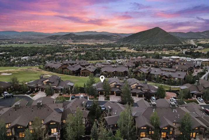 Aerial perspective of a residential community featuring multiple dark-roofed properties