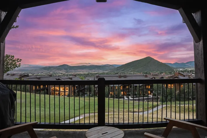 Twilight views, outdoor deck with dark wood railing and metal balusters