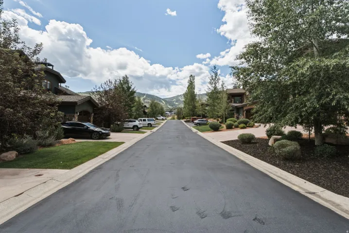 Fairway Ln. - quiet, wide street with mature trees and landscaped properties, featuring mountain scenery in the distance