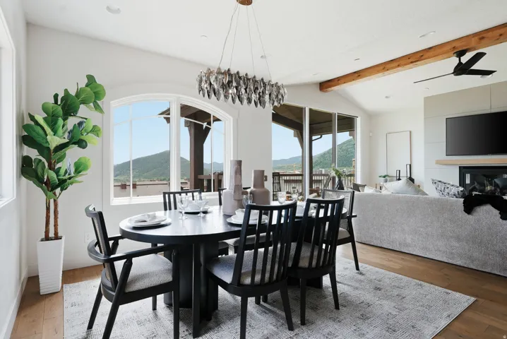 Dining area featuring a contemporary chandelier, arched window, and wood-finish flooring
