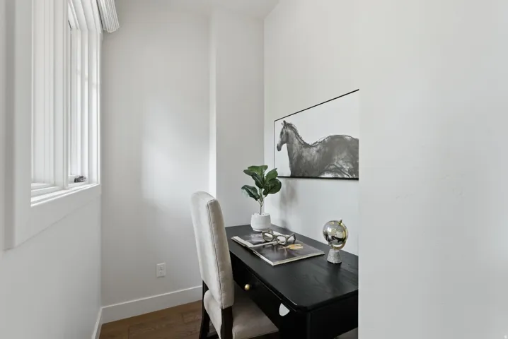 Recessed nook featuring wood-finish flooring, a white trim window, and white walls. Could be used as a small office, mud room, etc