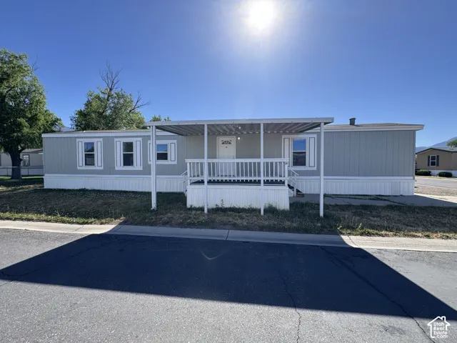 Light blue siding exterior with white trim and a covered front porch featuring white railings