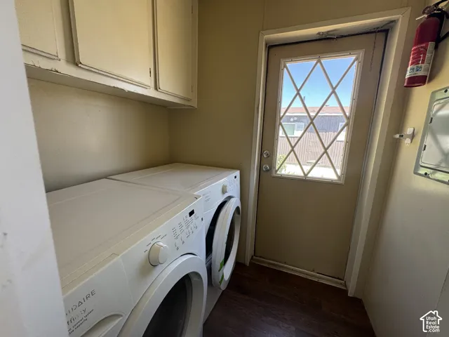 Utility area featuring a glass-paned door with diamond grilles, wood-finish flooring, and upper cabinetry