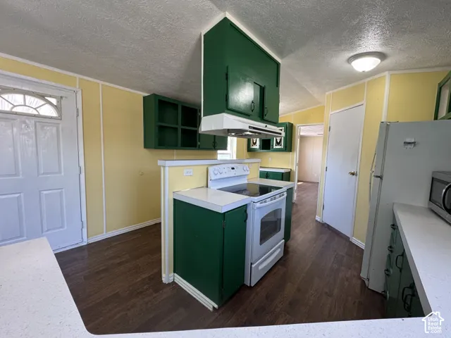 Kitchen featuring white appliances, green cabinetry, wood-finish flooring, light countertops, and paneling on walls