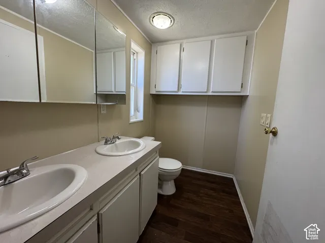 Bathroom featuring a dual vanity with laminate countertop, integrated sinks, and chrome faucets