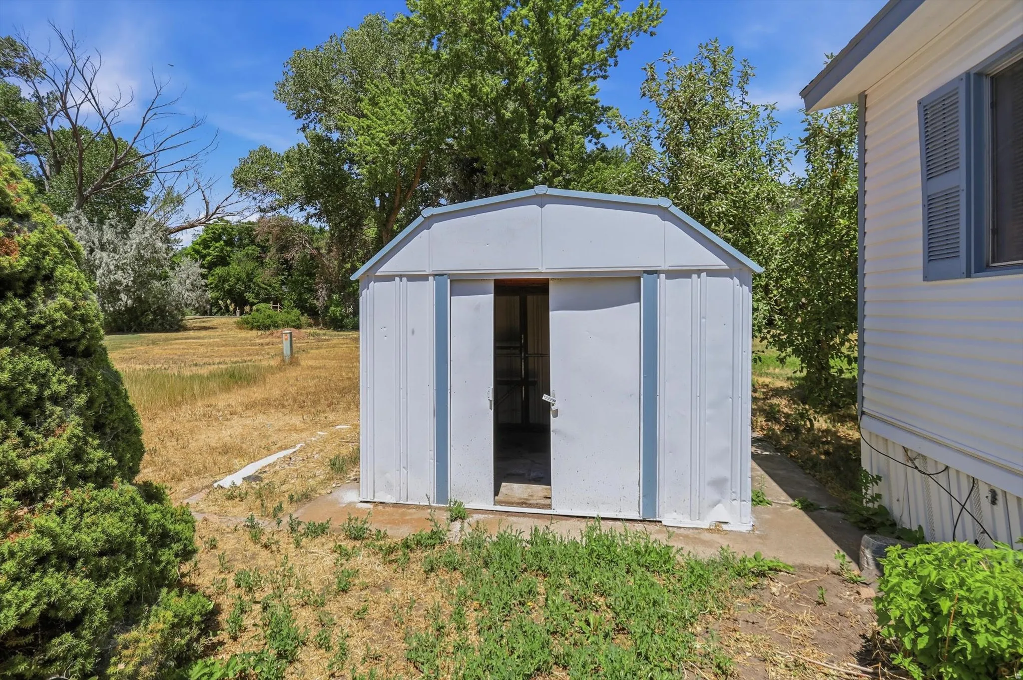 White metal storage shed with an arched roof
