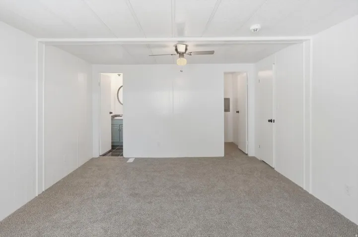 Carpeted interior space featuring white walls and a white paneled ceiling