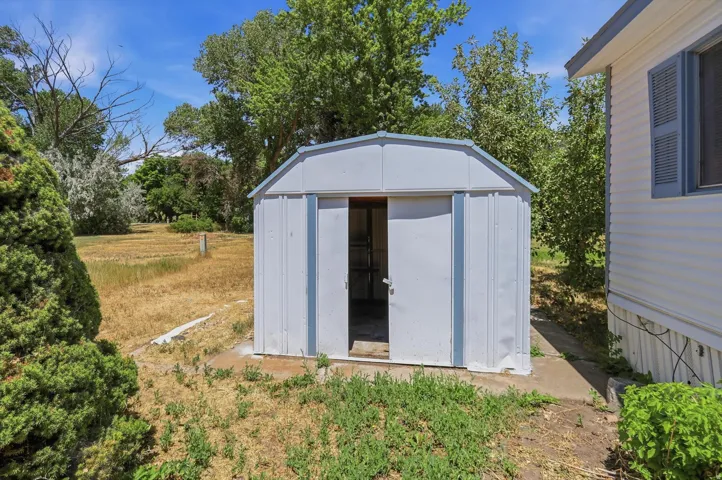 White metal storage shed with an arched roof