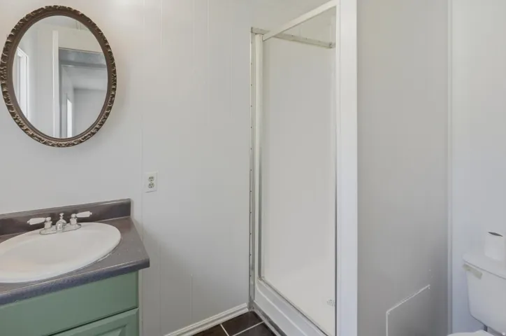 Bathroom featuring a corner shower enclosure and a vanity with an integrated sink