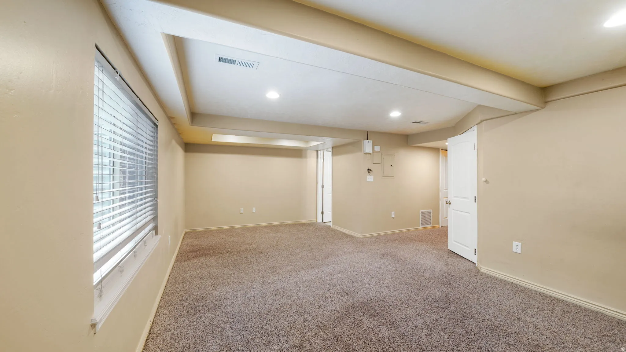 Spacious room featuring neutral carpeting and light beige walls
