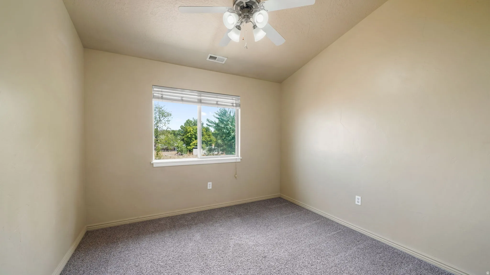 Carpeted room with a ceiling fan, a window featuring horizontal blinds, and neutral-toned walls