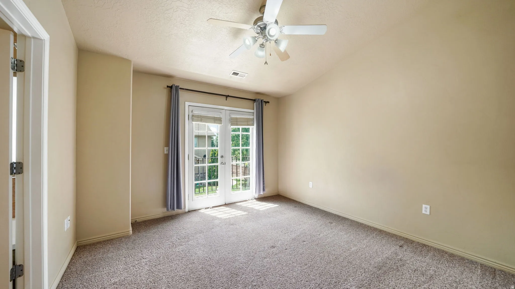 Vaulted ceiling room featuring light-toned carpeting and neutral wall tones