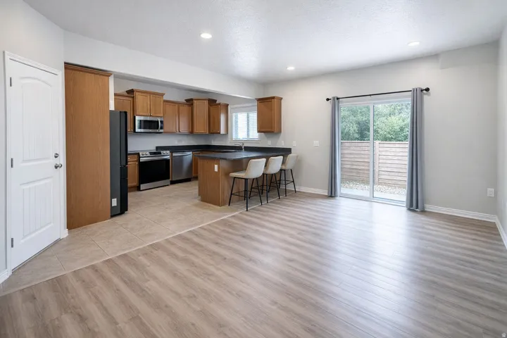Open-concept living space featuring wood-finish flooring, recessed lighting, and a sliding glass door