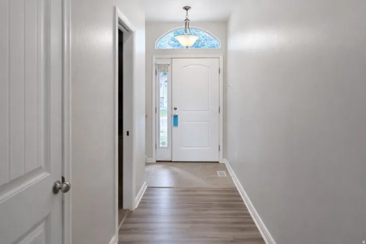 Entryway featuring wood-finish flooring, a paneled door, and a transom window above the main entrance