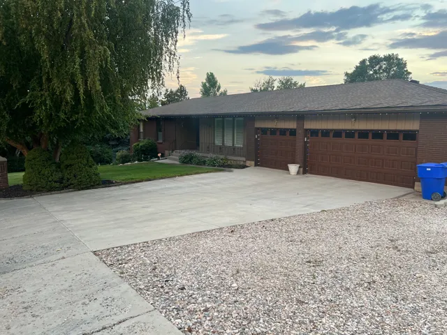 Brick exterior with a brown shingle roof and a two-car garage