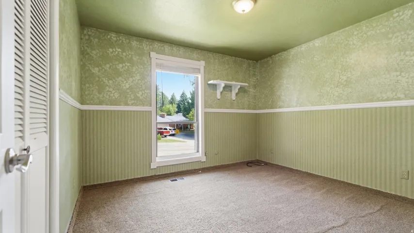 Interior room featuring carpet flooring and a window with white trim
