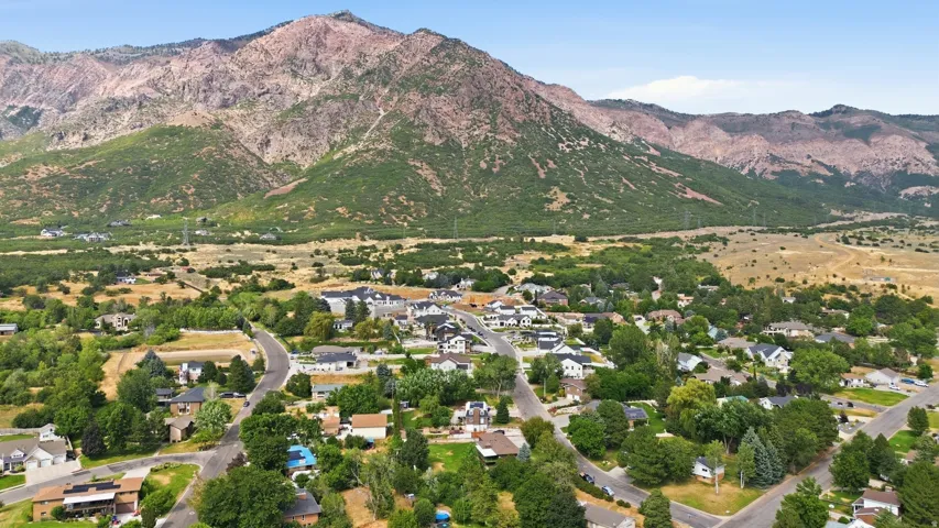 Residential community nestled at the base of rugged mountains with varied terrain