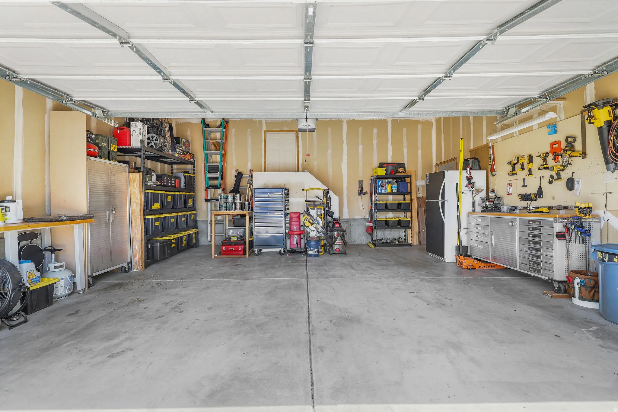 Spacious garage featuring a concrete floor, exposed ceiling joists, and direct interior access