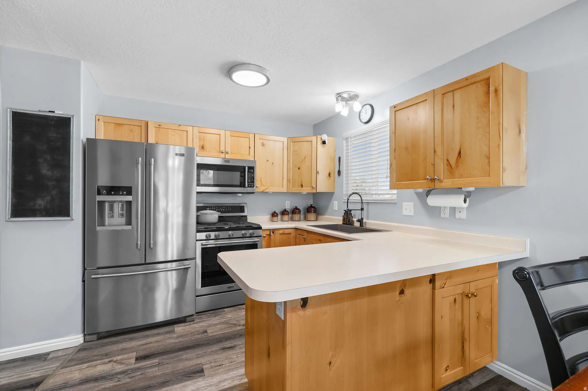 Kitchen featuring light wood cabinetry, stainless steel appliances