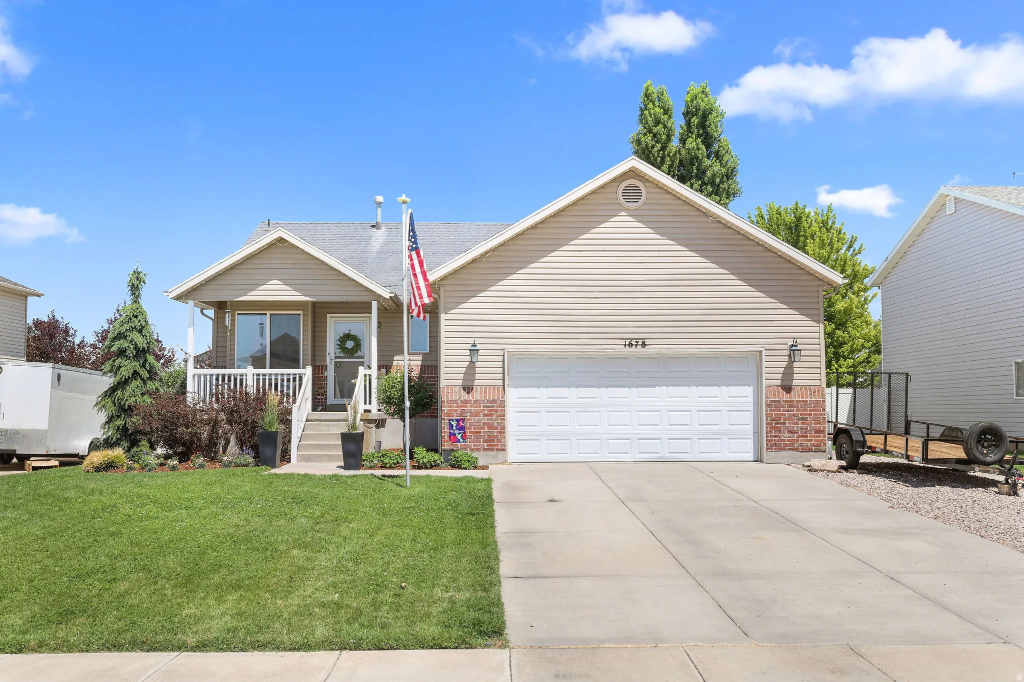 Single-family home featuring a two-car garage, concrete driveway, and a covered front porch